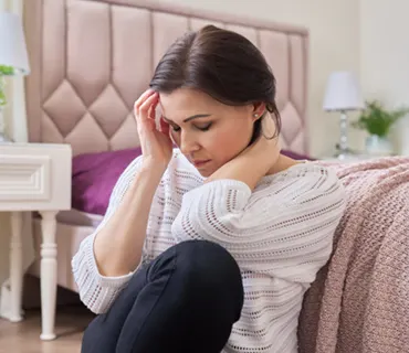 Femme fatiguée souffrant de maux de tête, migraine, femme assise à la maison sur le sol